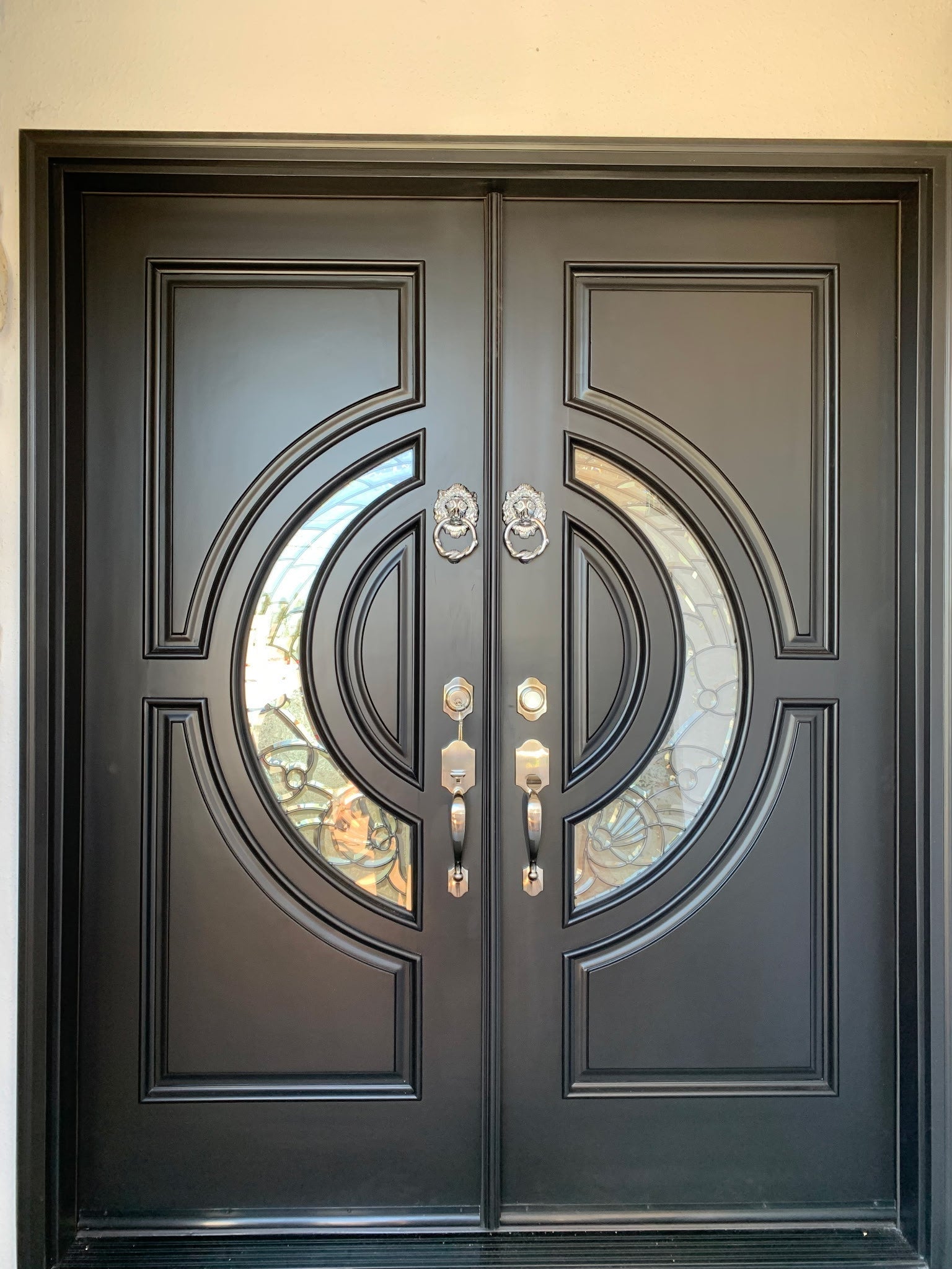 black wood double front door with crescent glass