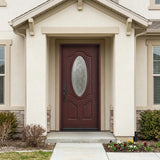 Single fiberglass front door with oval glass and dark mahogany stain installed on a house