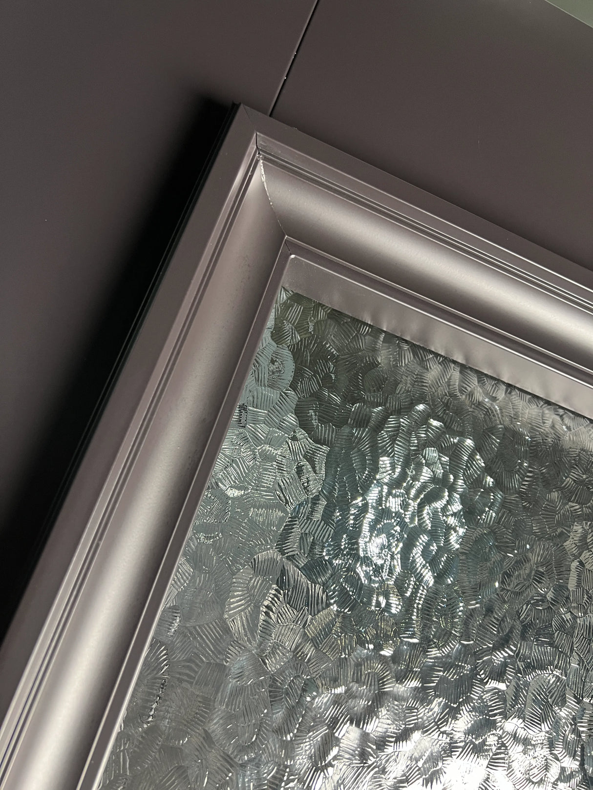 Close-up of textured glass and iron frame detail on double front entry door