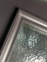 Close-up of textured glass and iron frame detail on double front entry door
