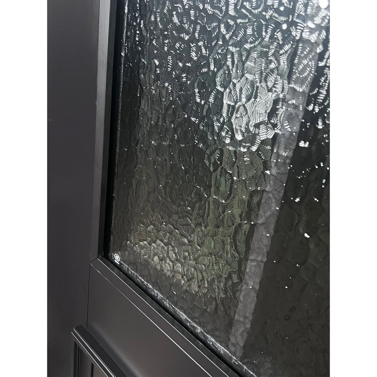 Close-up of textured glass panel on iron double front entry door with black metal grid