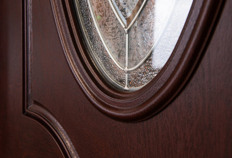Close-up of decorative glass and textured wood grain surface on fiberglass entry door showing detail and material finish