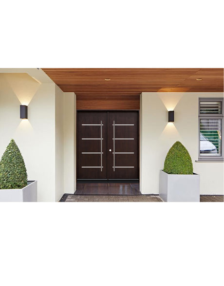 Double front entry door installed on home exterior with wood finish and modern panel design