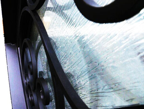 Close-up of rain glass panels on black iron double door showing textured privacy glass design